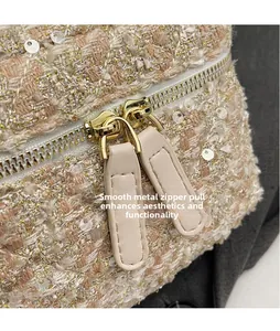 Macro shot of smooth gold zipper hardware on pink sequined tweed crossbody bag detail