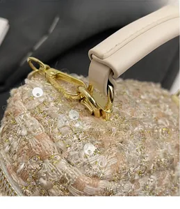 Macro shot of gold hardware hook and sequined bouclé tweed texture on the crossbody bag