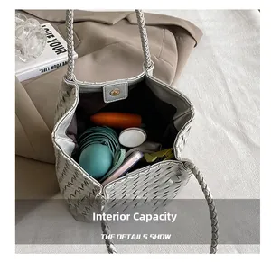 Detailed interior of silver woven tote showing large capacity and magnetic closure