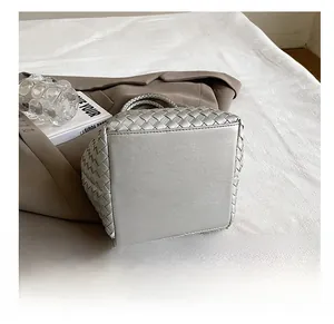 Detailed bottom view of silver woven bucket bag showing reinforced base and neat stitching