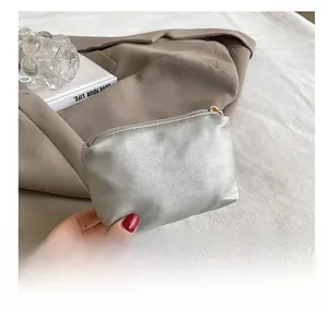 Detailed view of a silver metallic textured mini clutch bag with a secure zip closure