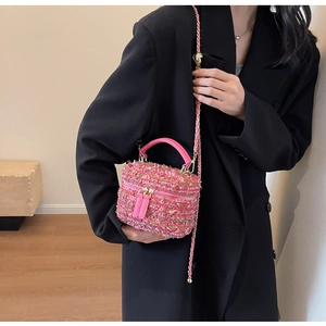 Detail der rosa Tweed-Box-Tasche mit bunten Nähten und goldener Herz-Kettenschulter