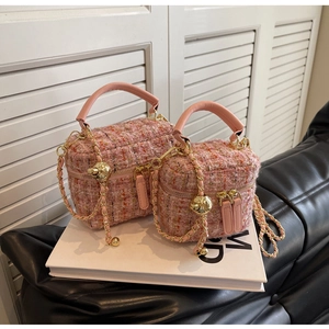 Detail view of pink tweed box bags showing textured fabric and golden ball chain