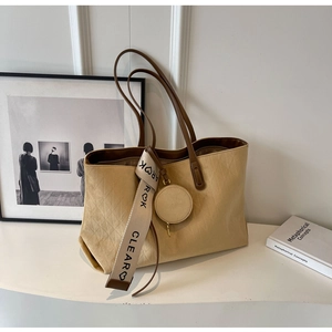 Detail of beige quilted tote bag with suede texture, round pouch and CLEAROK strap