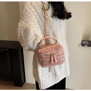 Detail of the pink tweed box bag with gold chain strap and adjustable spherical buckle