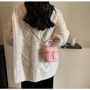 Details der rosa Tweed-Minitasche mit Ledergriff und Metallkettenriemen am Modell