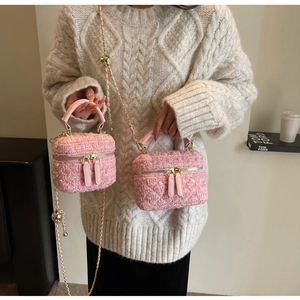 Détail du mini sac en tweed rose avec double zip doré et bandoulière en chaîne
