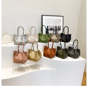 Detailed display of ten colorful woven leather handbags arranged on a white tiered stand