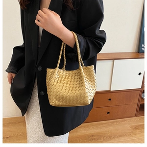 Close-up of golden woven leather texture and handle on a luxury French style tote bag