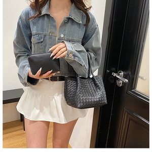 Detail of black woven leather tote and matching pebbled clutch with street style styling