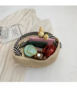 Detail view of large capacity straw woven bag showing interior storage and accessories