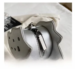 Detail view of the smooth metal zipper and silver leather texture on the dinosaur bag