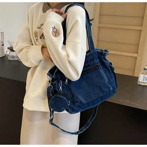 Dettaglio borsa tote in denim blu con tasca esterna e mini portamonete coordinato