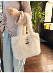 Detail der beigen Kunstpelz-Handtasche mit Knebelverschluss und weichem Plüsch
