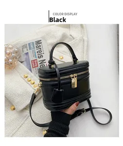 Detail view of mini black leather handbag with gold zippers and adjustable shoulder strap