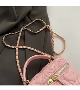 Detail of pink quilted vanity bag showing the soft leather strap and golden chain link