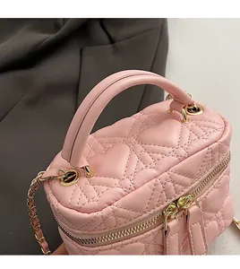 Detail of pink quilted leather mini box bag with gold zipper and comfortable handle