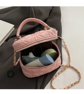 Detailed interior of a pink quilted mini bag showing storage capacity and golden chain strap