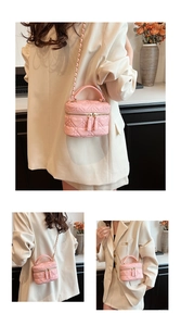 Detail of pink heart-shaped quilted mini bag with golden chain and top handle