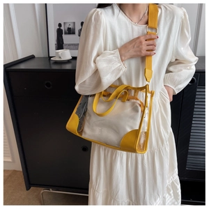 Detail of yellow transparent PVC tote with a white fabric inner bag and wide shoulder strap