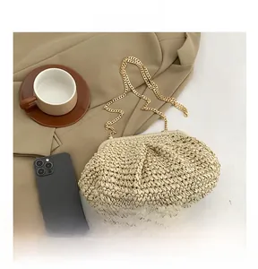 Close-up of beige woven pouch bag with gold chain strap on a khaki blazer background