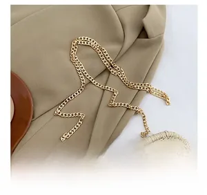 Detail of elegant gold metal chain strap on a handmade woven straw bag for women