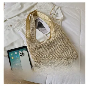Vue détaillée du grand sac en paille montrant la capacité pour iPad et téléphone
