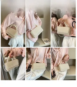 Detail of elegant pearl woven handbag showing crossbody and handheld styling on model