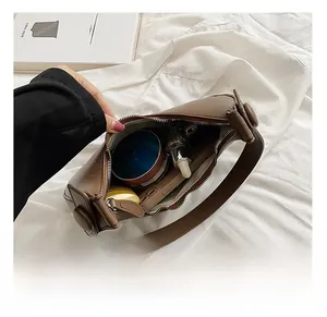 Interior view of brown leather shoulder bag showing daily capacity for phone and cosmetics
