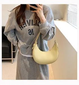 Detail of minimalist pale yellow PU leather crescent bag with smooth matte finish