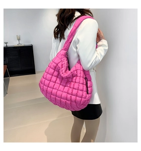 Detail of bright pink quilted air cotton crossbody bag on shoulder in modern street style