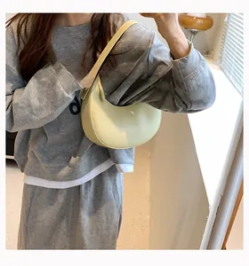 Detail view of a vintage pale yellow crescent shoulder bag with smooth matte leather finish