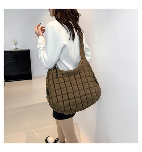 Close-up of brown quilted puffer shoulder bag showing square grid texture and large capacity