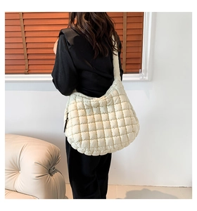 Close-up of beige quilted oversized cloud bag showing soft padded texture and strap