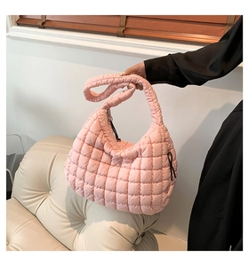 Detail of pink quilted hobo bag with padded texture and wide shoulder strap