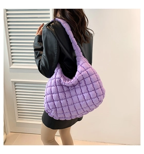 Detail of purple quilted puffer bag in lightweight fabric worn with a black leather jacket