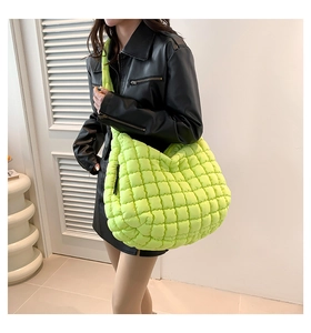Detail of a oversized lime green quilted bubble bag with padded wide shoulder strap