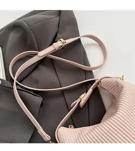Détail du sac à main plissé rose avec bandoulière réglable et boucle dorée