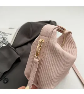 Détail du sac plissé rose clair avec crochet amovible en métal doré pâle et texture fine