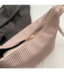 Détail du zip en métal doré lisse sur le sac à main plissé rose pour femme