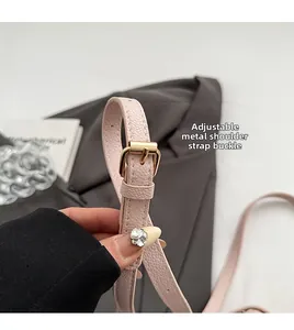 Détail de la bandoulière réglable en cuir rose avec boucle en métal doré poli