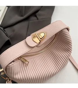 Gros plan du sac en cuir plissé rose avec fermoir doré et finition texturée élégante