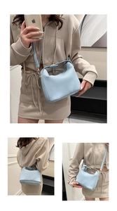 Détail d'un sac à main bleu clair plissé montrant la texture et la bandoulière réglable