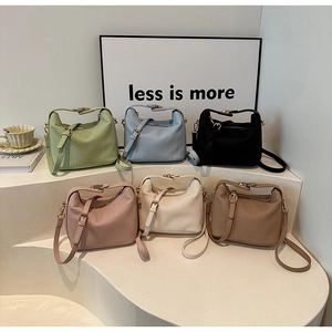 Détail de divers sacs bandoulière plissés en six couleurs tendance sur un présentoir