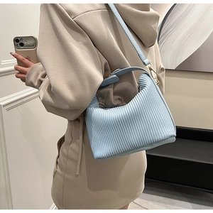 Détail du sac à bandoulière plissé bleu clair sur mannequin pour référence de style