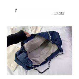 Détail du sac en jean montrant la doublure grise spacieuse et la poche intérieure zippée