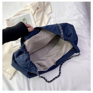Detail of denim tote bag showing interior lining, zipper pocket and magnetic closure