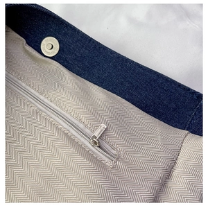 Close-up of denim tote interior with chevron lining and secure magnetic metal snap closure