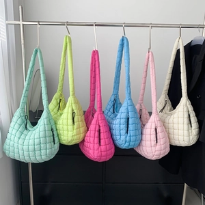 Fashionable quilted puffy cloud shoulder bags in multiple vibrant colors hanging on a rack