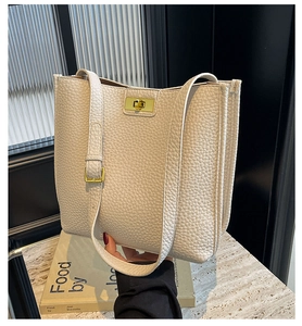 Dettaglio della borsa tote in pelle martellata bianco sporco con chiusura a scatto dorata